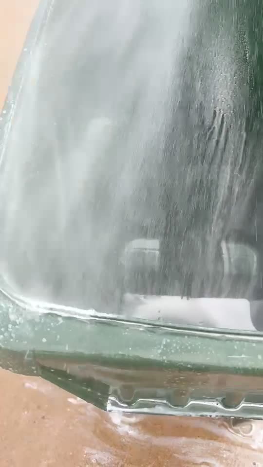 Pressure washing soapy foam inside a trash bin